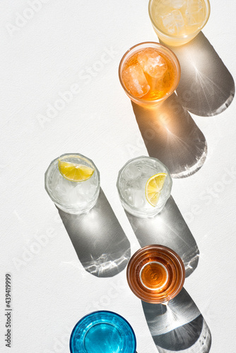 Fotografi Summer drinks with ice and citrus fruits in colorful glasses