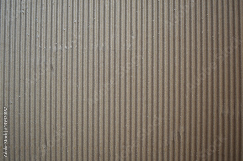 Dark brown color corrugated cardboard box textured background with vertical ridges