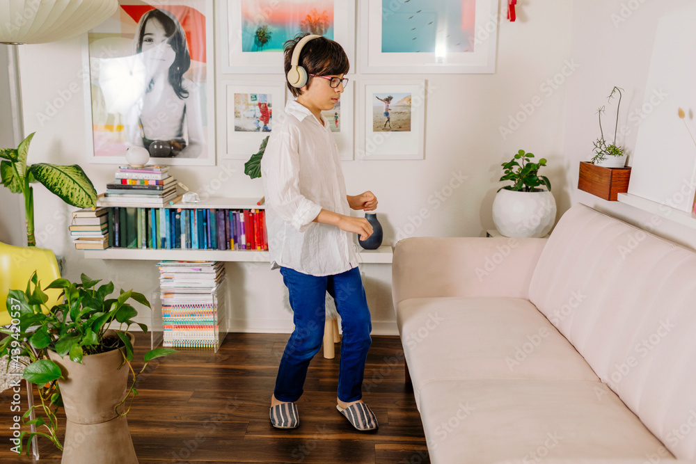 Teen Boy dancing and singing by colorful books and wall gallery Teen Boy dancing and singing by colorful books and wall gallery