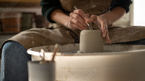 Close up of ceramist woman Making Clay bowl With Pottery lathe in her studio photo