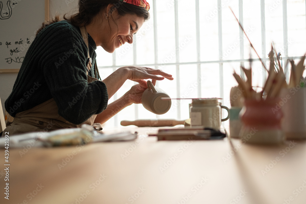 Ceramist young woman Making Clay cups in her studio Ceramist young woman Making Clay cups in her studio