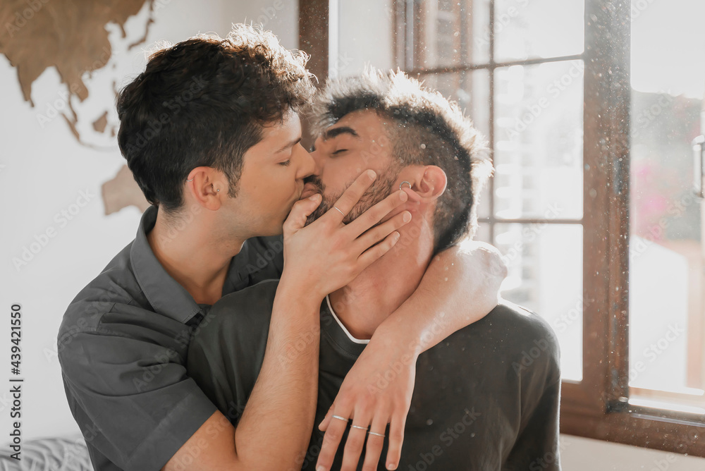 Same sex couple hugging and kissing in the room. Same sex couple hugging and kissing in the room.