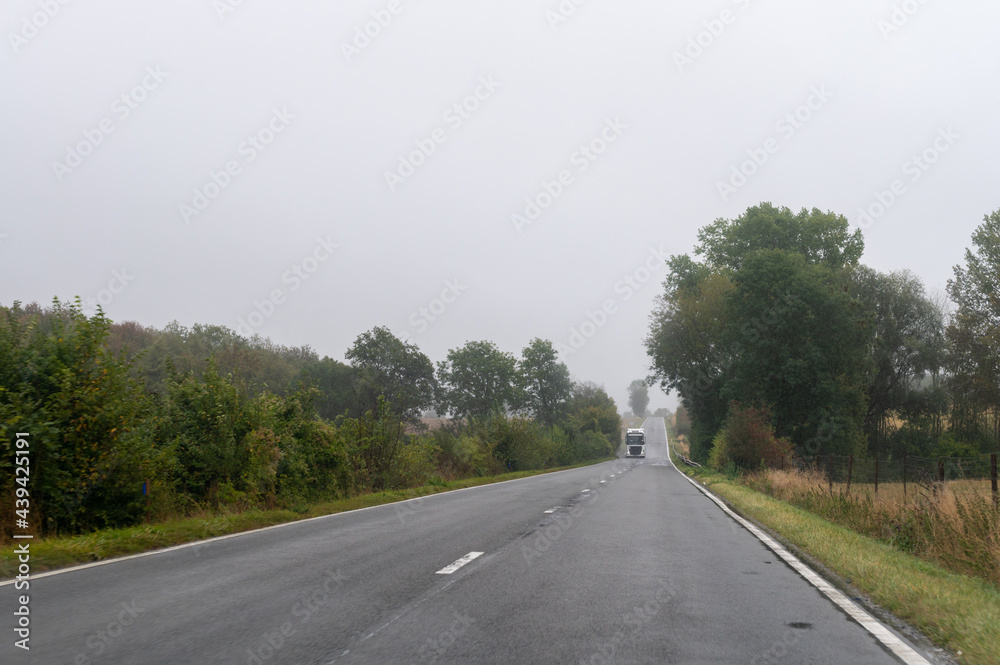 Fototapeta premium Driving on asphalt road in cloudy rainy day