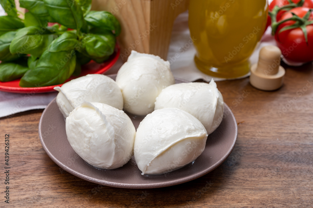 Cheese collection, small fresh white soft mozzarella cheese balls served with red tomatoes and fresh green basil from Italy Cheese collection, small fresh white soft mozzarella cheese balls served with red tomatoes and fresh green basil from Italy
