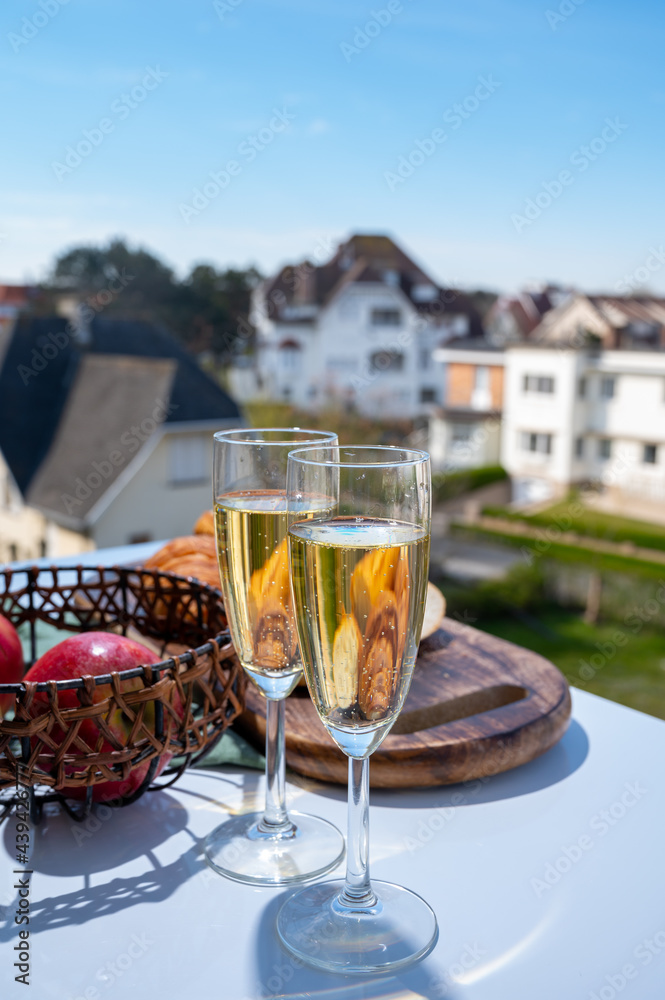 Drinking of brut champagne sparkling wine in flute glasses on outdoor bistro terrace in France Drinking of brut champagne sparkling wine in flute glasses on outdoor bistro terrace in France