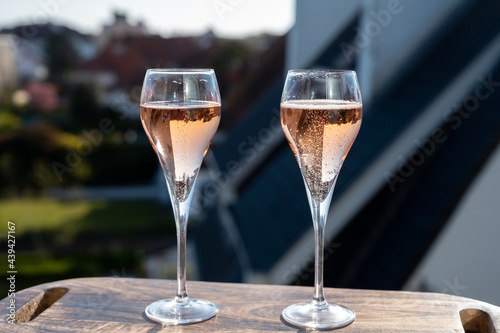 Tela Drinking of rose champagne sparkling wine from flute glasses on outdoor terrace