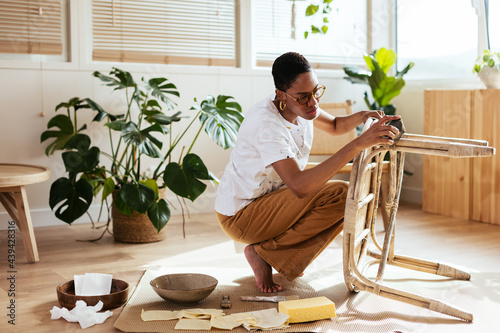 Black female artisan restoring bamboo table in studio photo