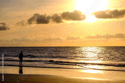 Lady walking on beach at sunrise on Jekyl Island,GA