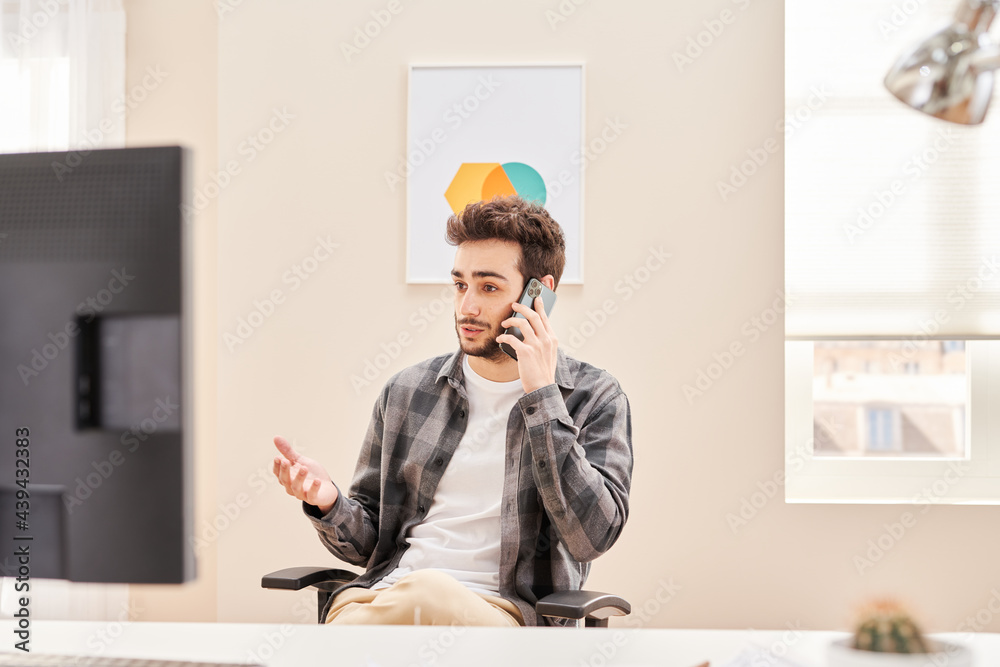 © Martí Sans/Stocksy - Modern male worker having phone call in office © Martí Sans/Stocksy - Modern male worker having phone call in office