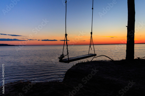 Fototapeta Naklejka Na Ścianę i Meble -  Rope swing on a shore of the Dnieper river in Ukraine at sunset