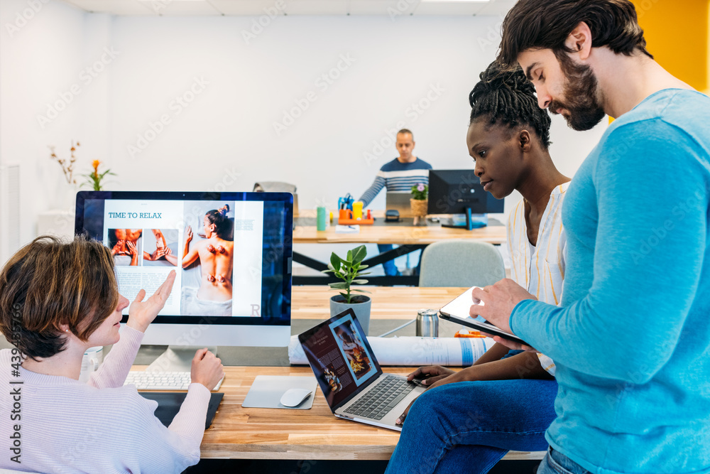 Multiracial coworkers working with gadgets in office Multiracial coworkers working with gadgets in office