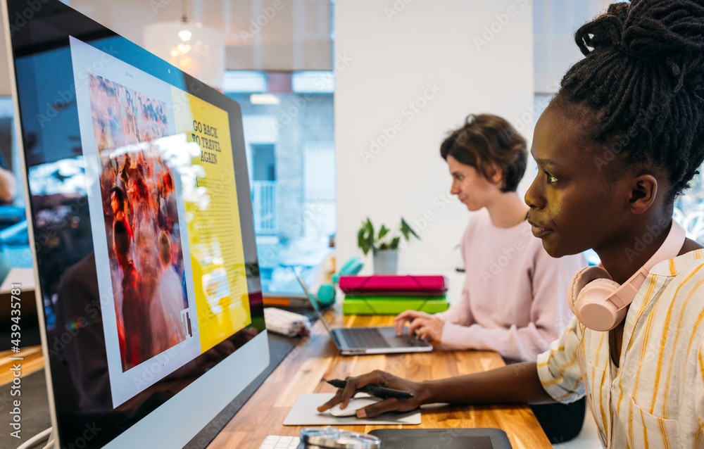 © VICTOR TORRES/Stocksy - Diverse colleagues working on modern gadgets in office © VICTOR TORRES/Stocksy - Diverse colleagues working on modern gadgets in office