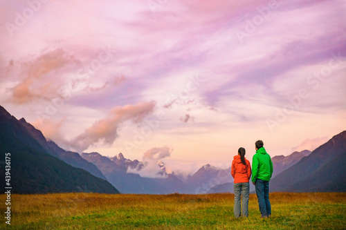 New Zealand hikers backpackers tramping on Routeburn Track, famous trail in the South Island of New Zealand. Couple looking at nature landscape. Fiordland and Mount Aspiring National Park, New Zealand