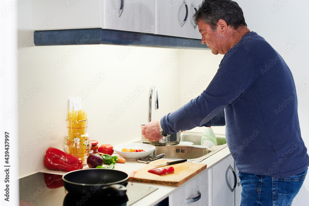 Mature man chopping red peppers for dinner Mature man chopping red peppers for dinner