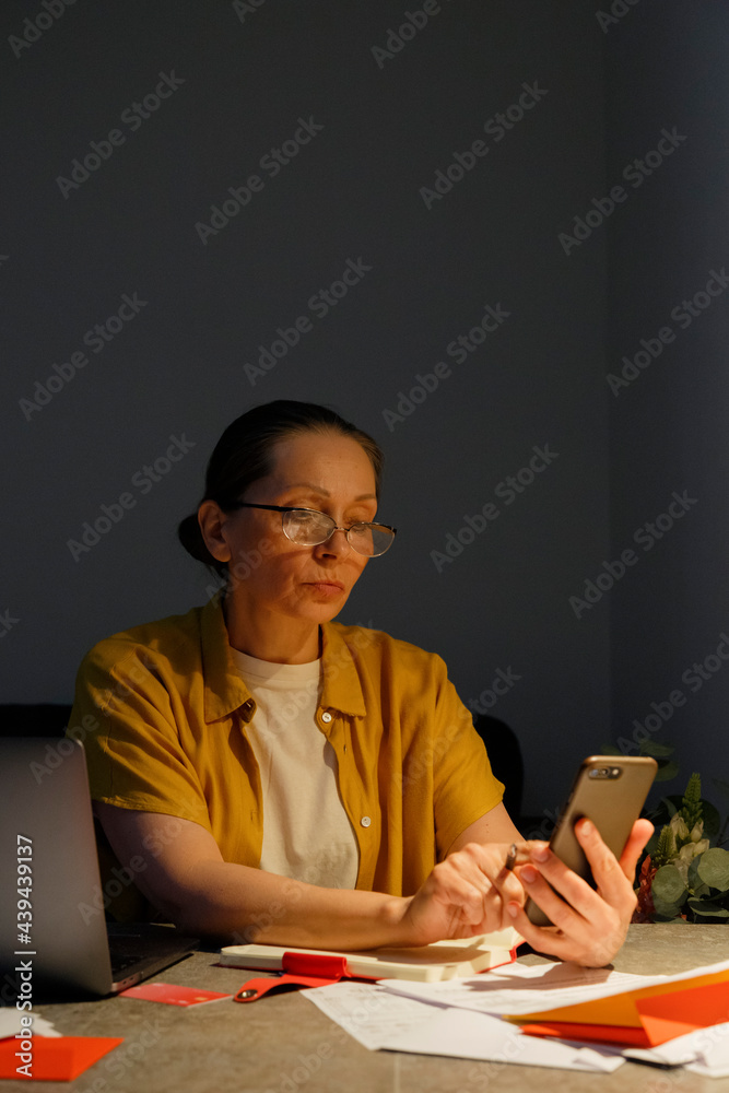 Mature accountant using smartphone during work Mature accountant using smartphone during work