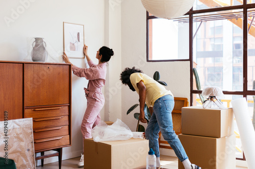 Diverse couple decorating new apartment
