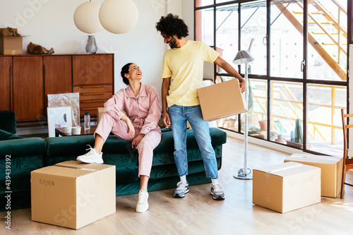 Multiracial couple laughing at joke during relocation