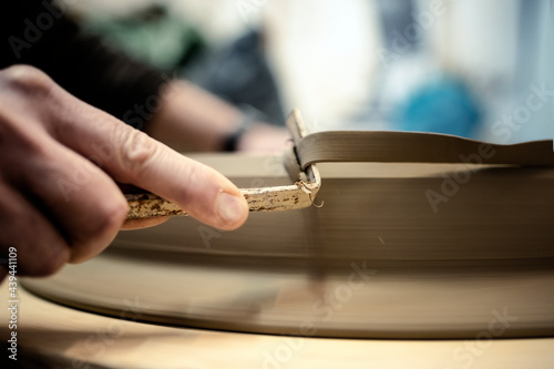 Person filing a ceramic piece ina workshop