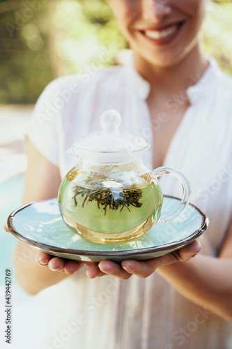 Spa therapist offering green tea to guest