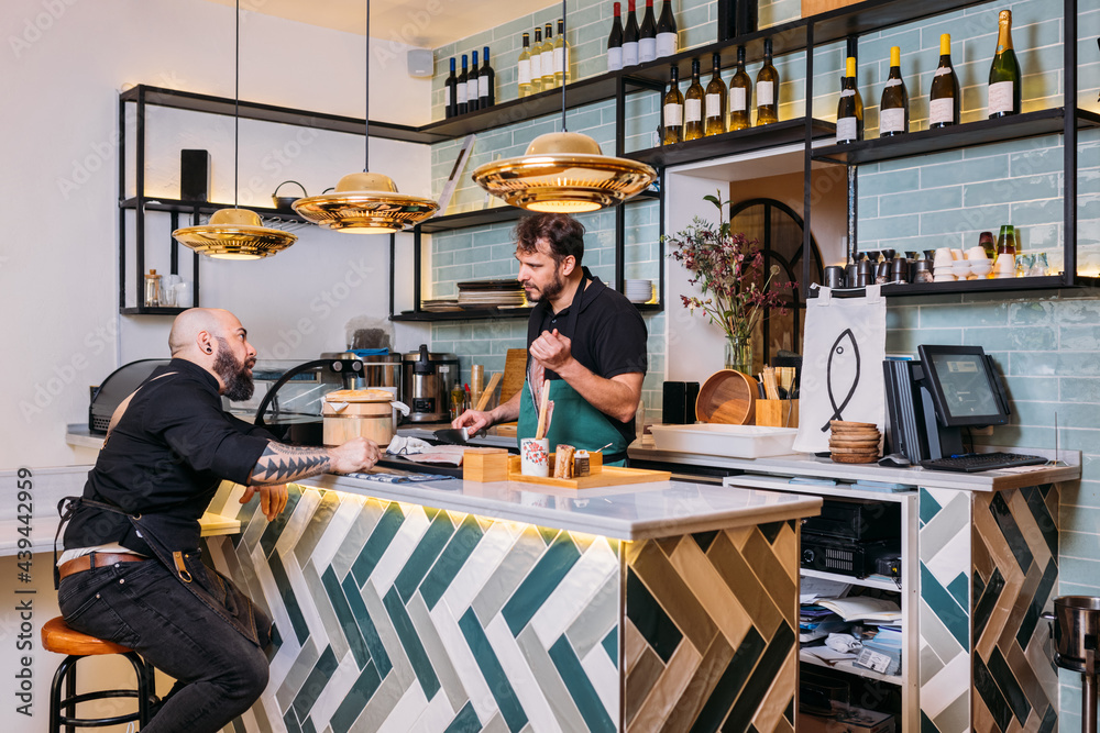 Male cooks at counter in cafe Male cooks at counter in cafe