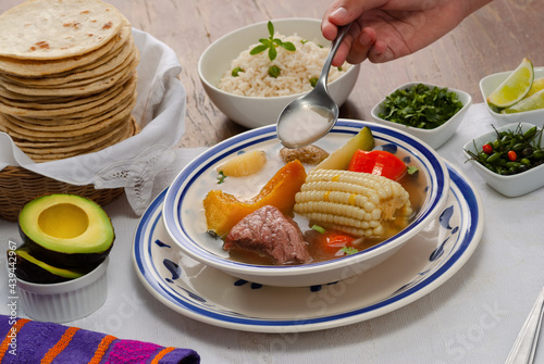 (Caldo de res)  traditional Guatemalan dish served with rice, vegetables, tortillas, and avocado. photo