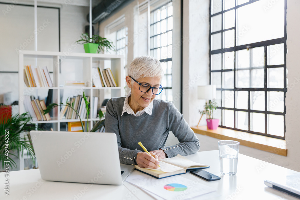 © Mihajlo Ckovric/Stocksy - Portrait of a senior businesswoman working in the office © Mihajlo Ckovric/Stocksy - Portrait of a senior businesswoman working in the office