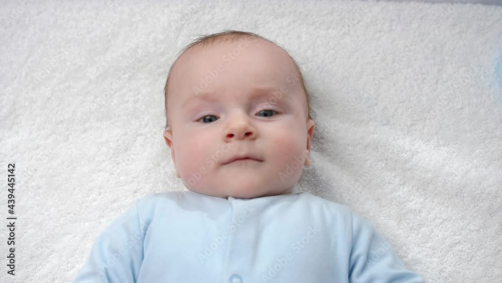 Portrait of cute baby with blue eyes lying and smiling in camera. Portrait of cute baby with blue eyes lying and smiling in camera.