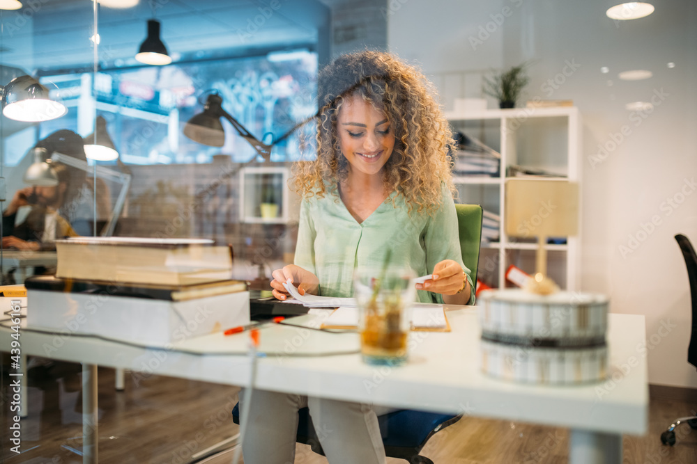 Smiling employee working on project at office desk Smiling employee working on project at office desk