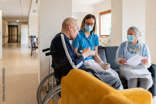 Two Nurses Taking Care Of Patient