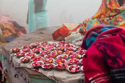 Small trays of flowers and candles sit for sale by street vendor photo