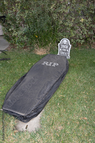 Suburbia backyard loan Halloween decorations featuring a tumbstone where RIP is written photo