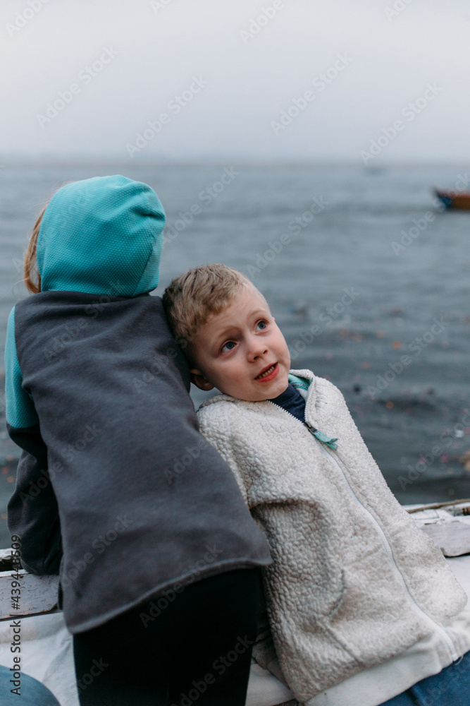A young brother leans against his sister on a boat A young brother leans against his sister on a boat