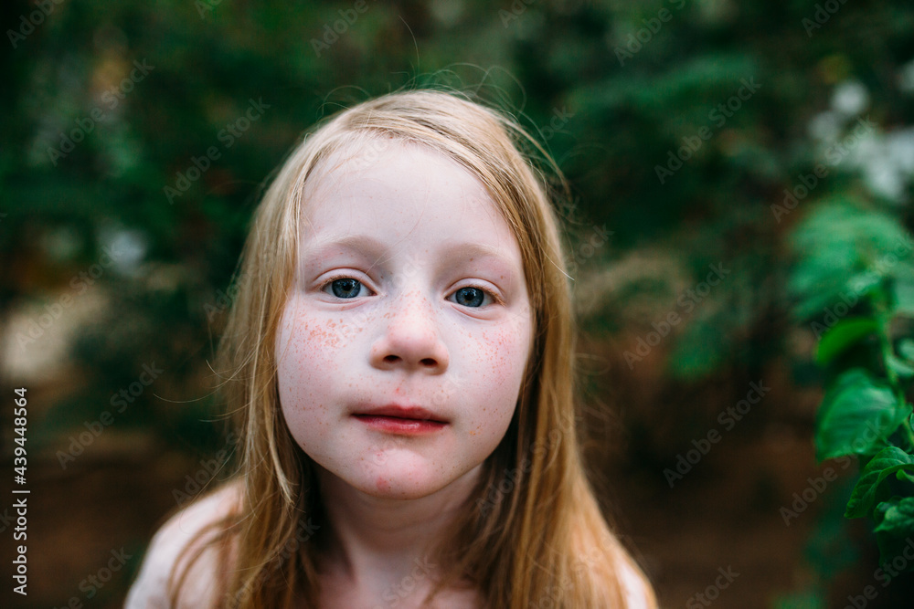 Portrait of a young girl with freckles in a tropical setting Portrait of a young girl with freckles in a tropical setting