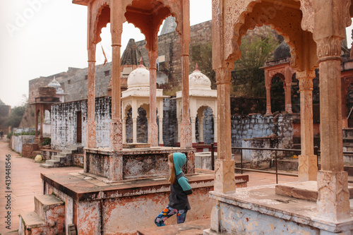 A little girl wandering around the tombs of a temple in rural India photo