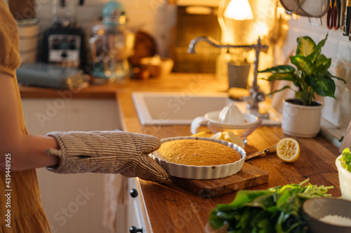 Female with potholder cooking pie photo