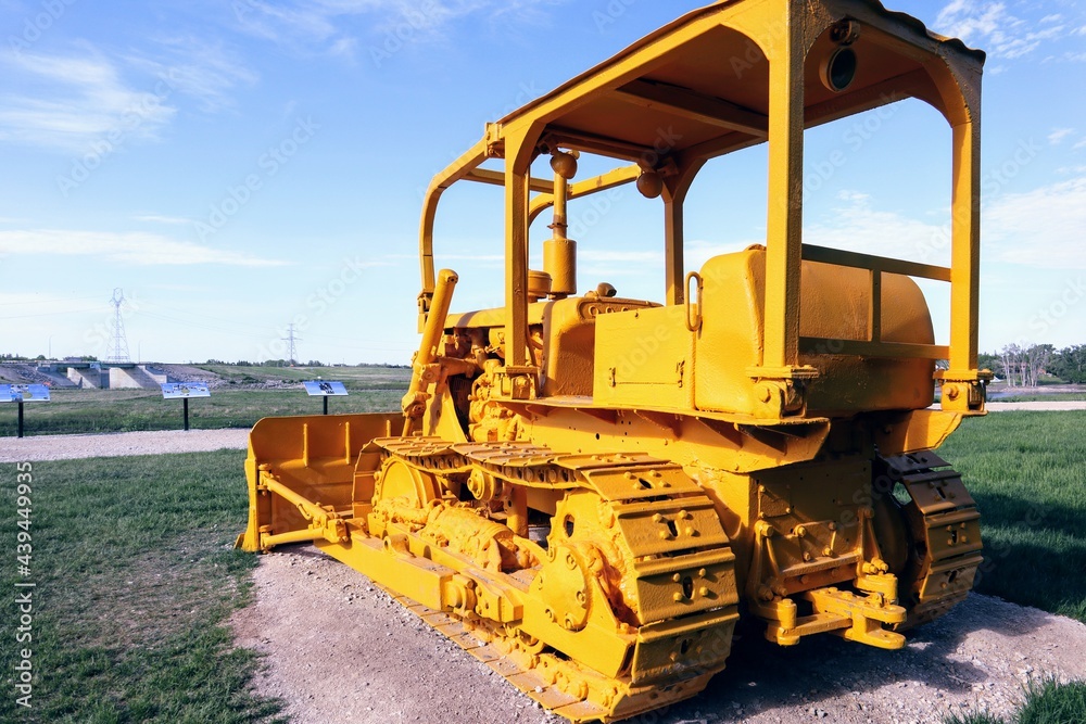 Close-up of a non-functioning bulldozer painted entirely in yellow paint Close-up of a non-functioning bulldozer painted entirely in yellow paint