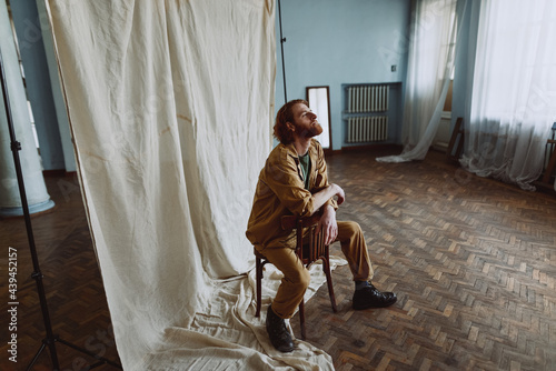 
Portrait of a red-haired bearded guy who sits on a chair photo