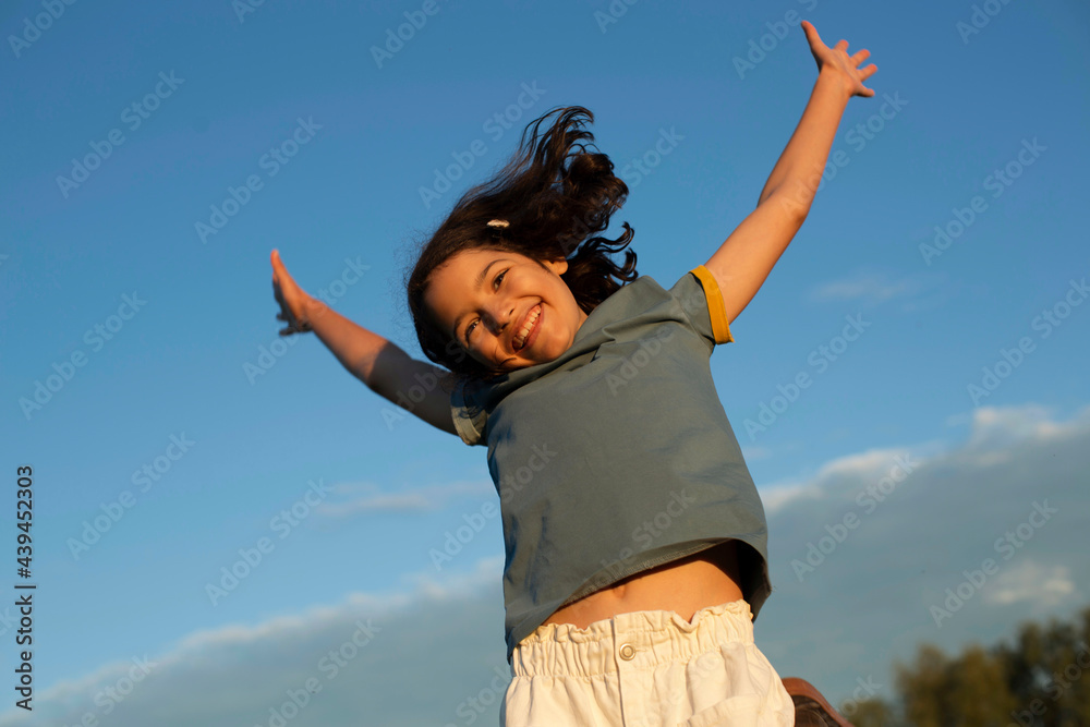Beautiful, jumping girl on a blue sky background Beautiful, jumping girl on a blue sky background