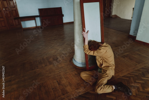 
portrait of a young red-haired man by the mirror