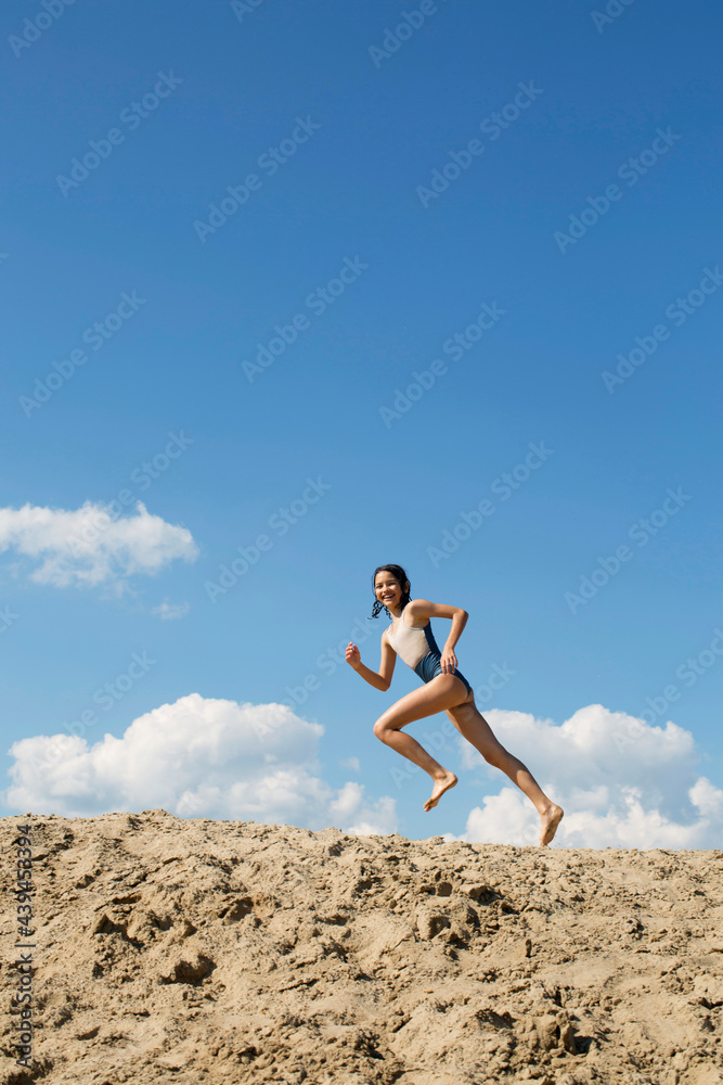 Cute girl is running on a sand 