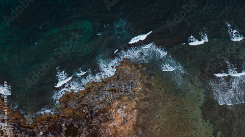 Ocean waves reach the rocks near the cliff