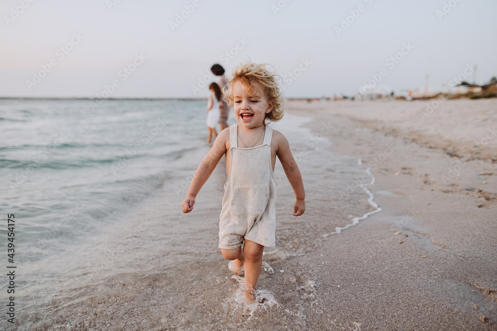 portrait of a little boy running along the seashore portrait of a little boy running along the seashore