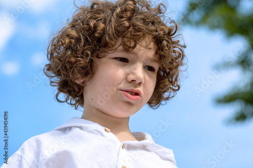 Portrait of a cute little boy with a curly hair.  photo