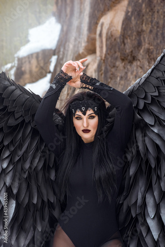portrait of a beautiful young brunette woman dressed as a black angel