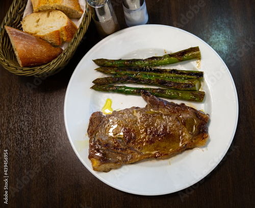 Appetizing beef entrecote served with baked asparagus and fresh bread..