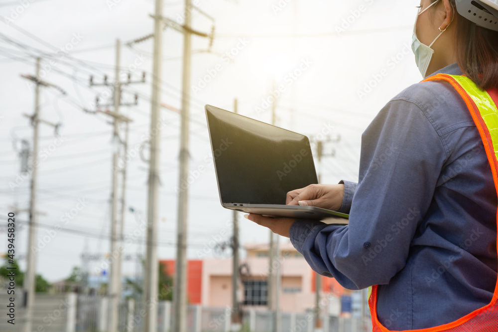 Female Engineer holding laptop working outdoor. Worker Woman use computer technology Female Engineer holding laptop working outdoor. Worker Woman use computer technology