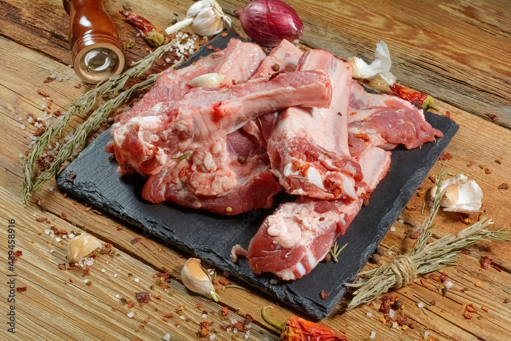 Raw pork ribs with spices on a wooden rustic background.Preparation of meat dishes.