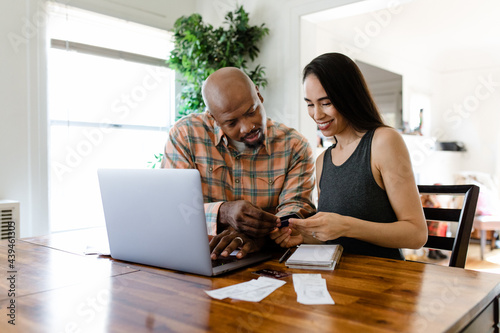 Young Couple Looks at Credit Card and Receipts