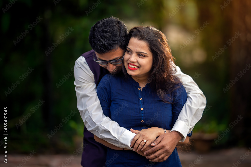 Happy attractive young couple hugging in forest Happy attractive young couple hugging in forest