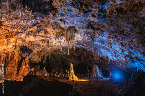 Speleologists admiring rocky calcite cave  photo